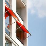 White building with red awnings against a blue sky.