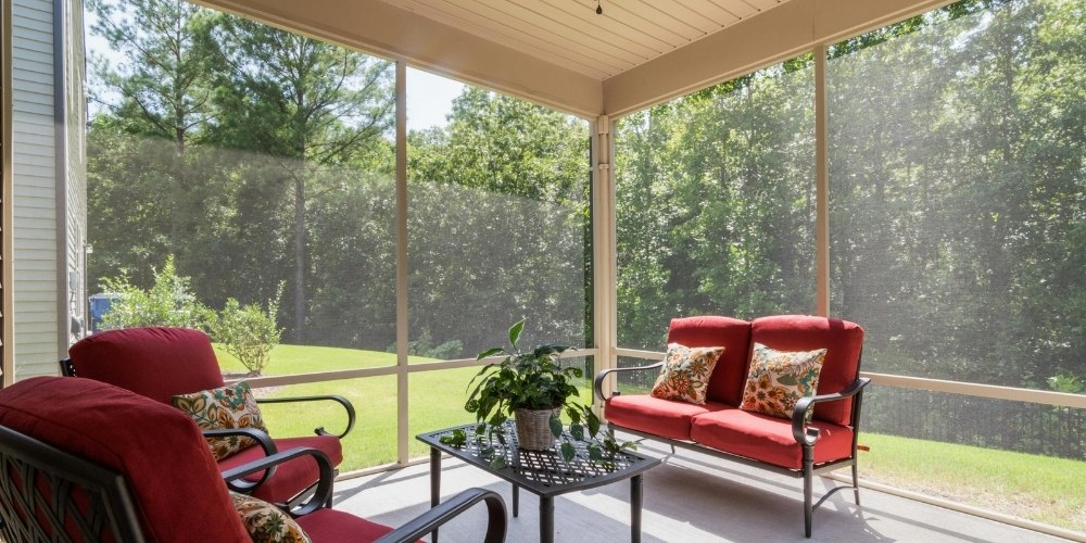 screened-in patio furnished with red-cushioned outdoor seating